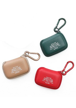 Three Hightide utility cases shown together in tan, dark green and red, each with a matching or contrasting carabiner clip.