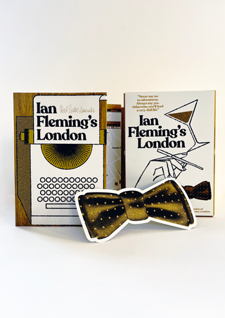 Overview of Ian Fleming's London, showing the guide's cover, wood-effect packaging, a bow tie-shaped card, and the fold-out map of London marked with numbered locations linked to Fleming's life, his work, and James Bond, alongside text spreads and an illustration of the Ritz Hotel.